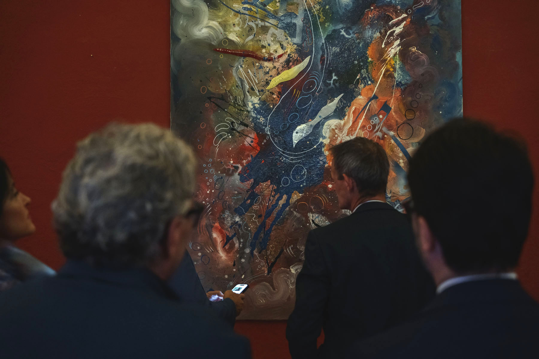 Visitatori davanti a un'opera della mostra SOGLIE
